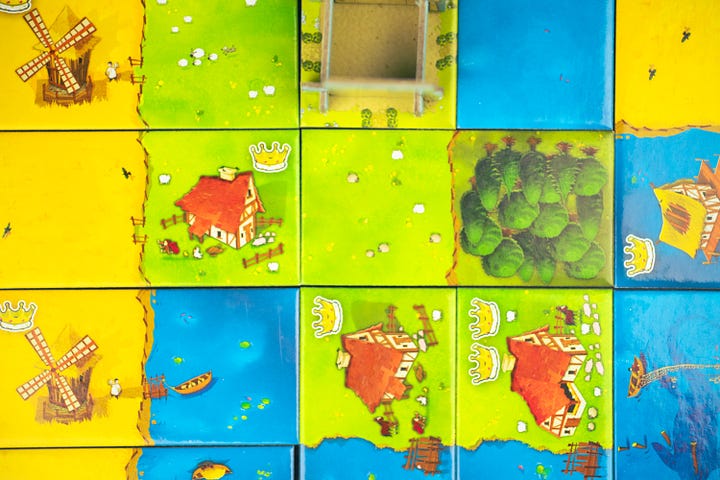 The games Kingdomino and Can't Stop, both set up for play.