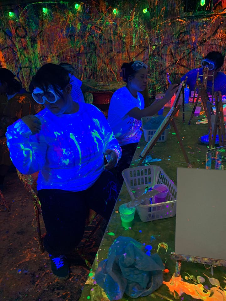 Graduate students paint their canvases and themselves with psychedelic neon paint