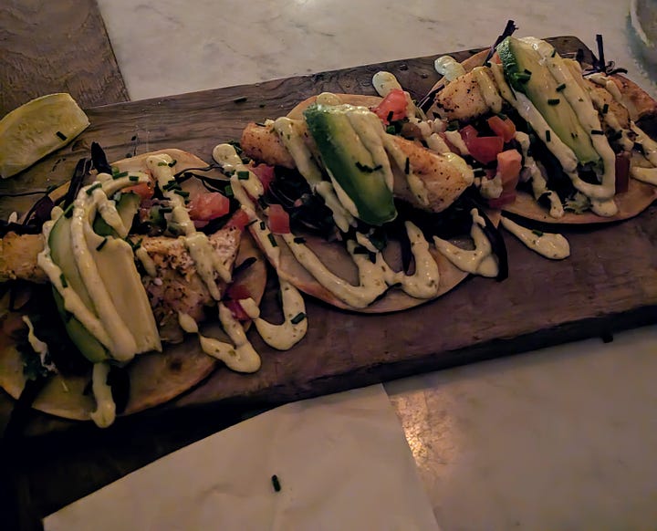 Left to right: Fish tacos topped with avocado and crema; fried chicken tacos topped with aioli and pico de gallo.