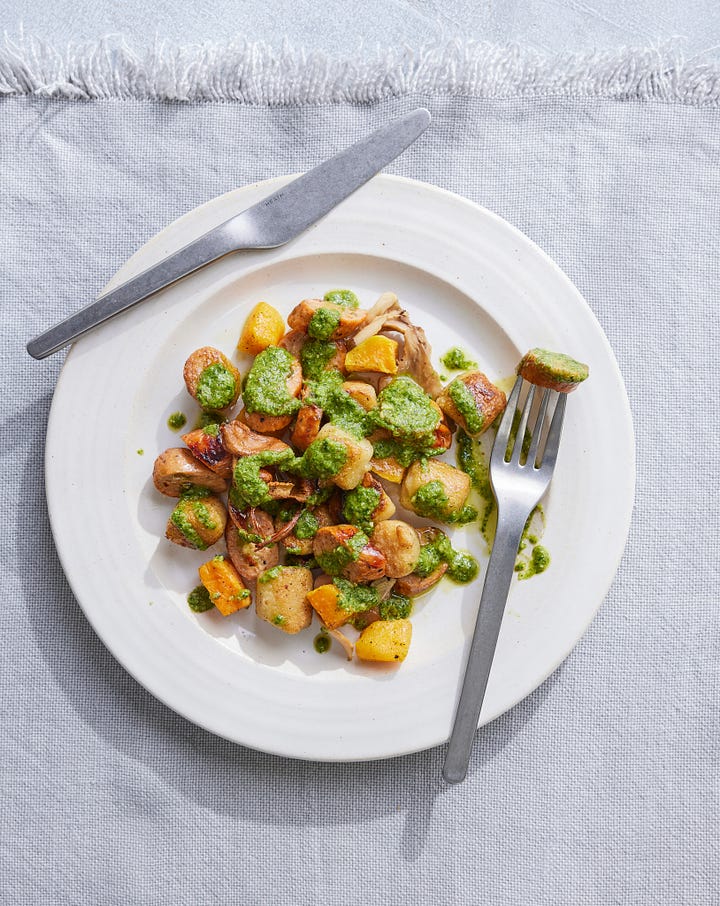 2 dinners- both with sausage and vegetables and a sauce, one in a skillet and one plated.