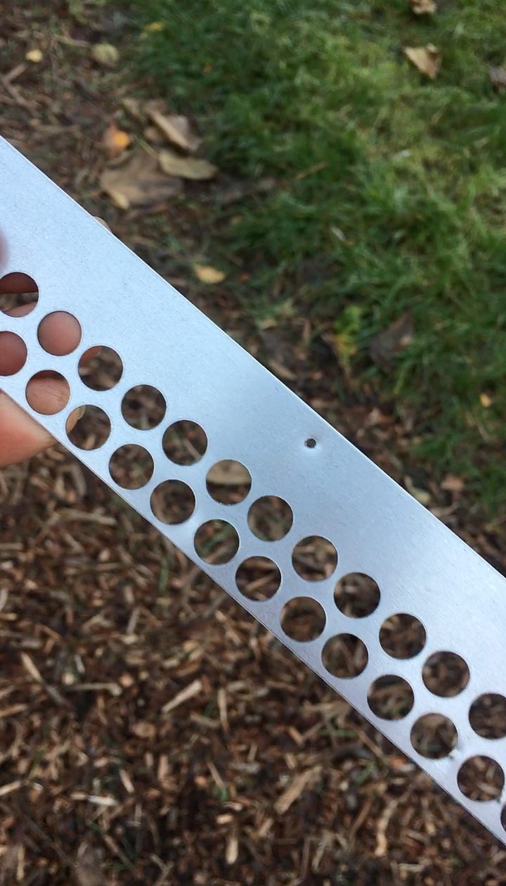 The warre hive busy with honeybees bringing in pollen on a warm October day; Having drilled holes in the metal mouse guard to fit to the entrance of the national honeybee hive ready for winter.