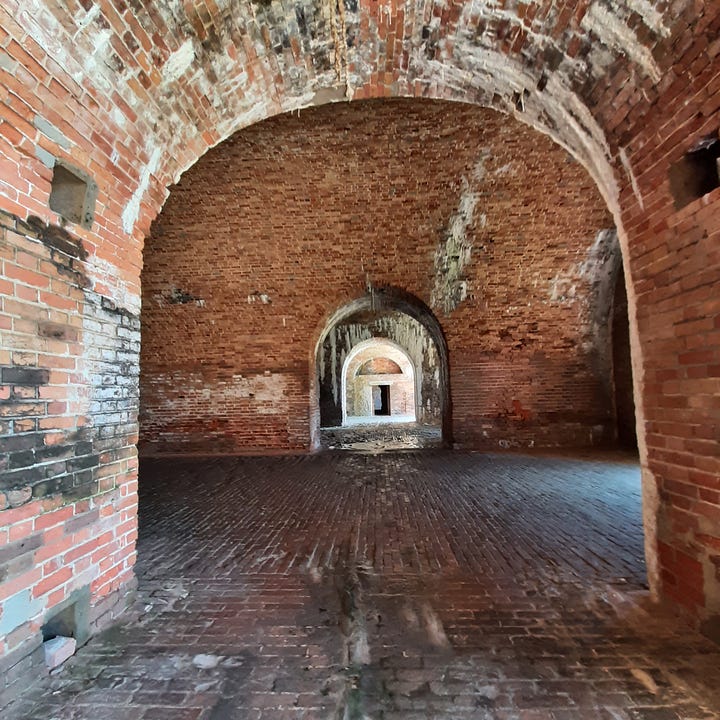 Inside Fort Morgan in Alabama with arched entrance ways to the rooms.