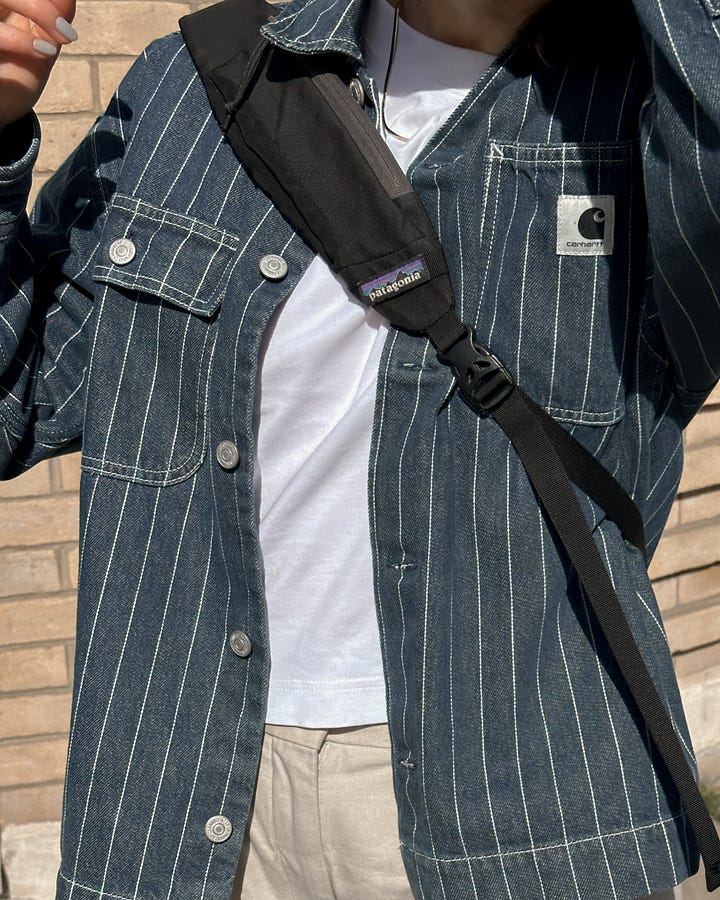 On the left, Lucy wears Carhartt stripe denim overshirt. On the right, Lucy stands in front of a green wall wearing a vintage beige golf jacket, green Sezane cardigan and white COS tee..