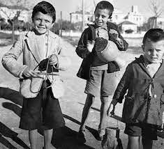 foto d'epoca in bianco e nero che ritraggono bambini impegnati nei canti natalizi greci