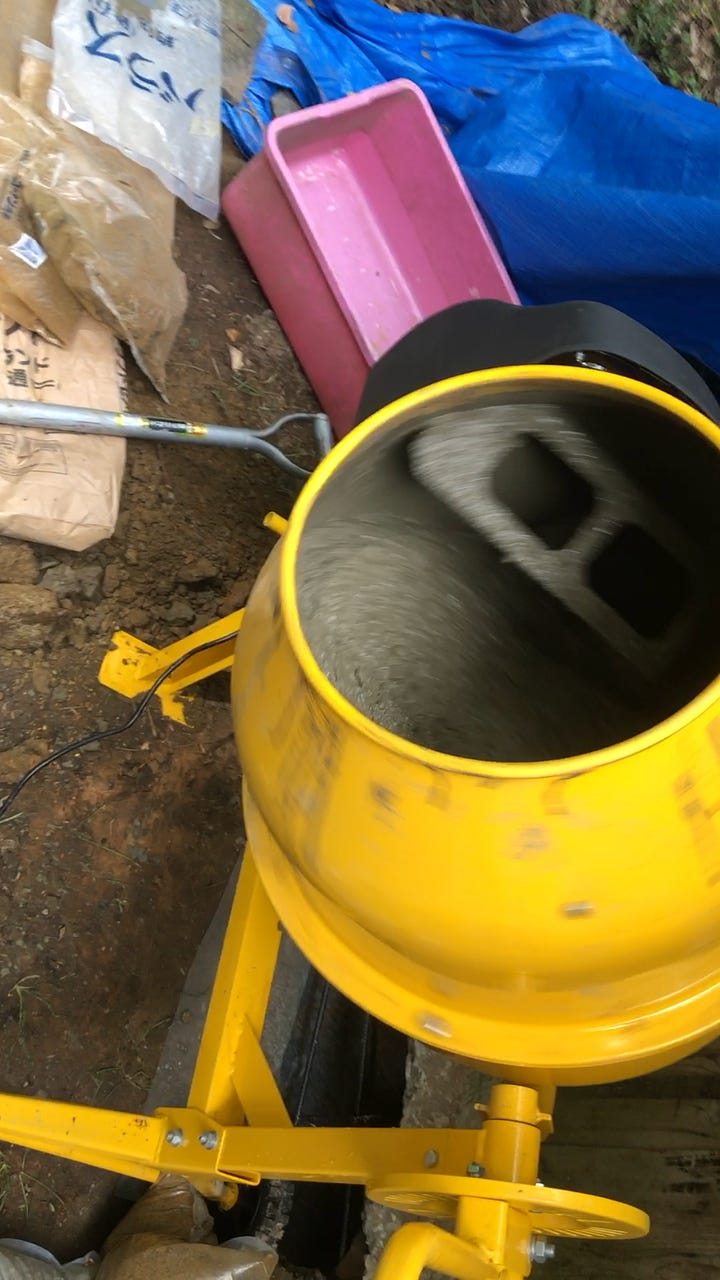 Digging under the old foundation to pour new reinforced concrete footings