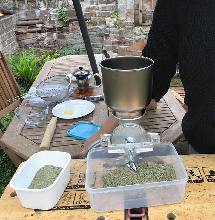 Metal grain grinder and handle attached to bench