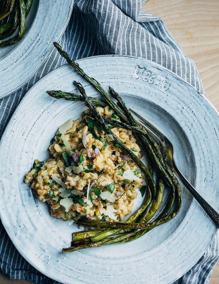 A bowl of farro risotto with roasted asparagus alongside; bowl of cream of asparagus soup.