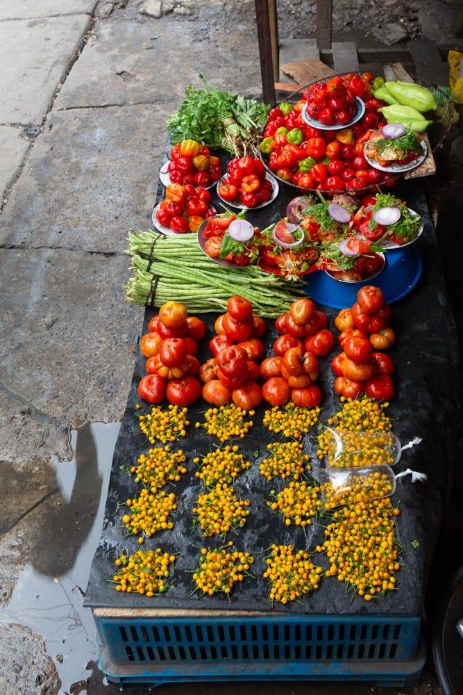 Colorful peppers and produce are neatly arranged into bundles and stacks at Belén Market.