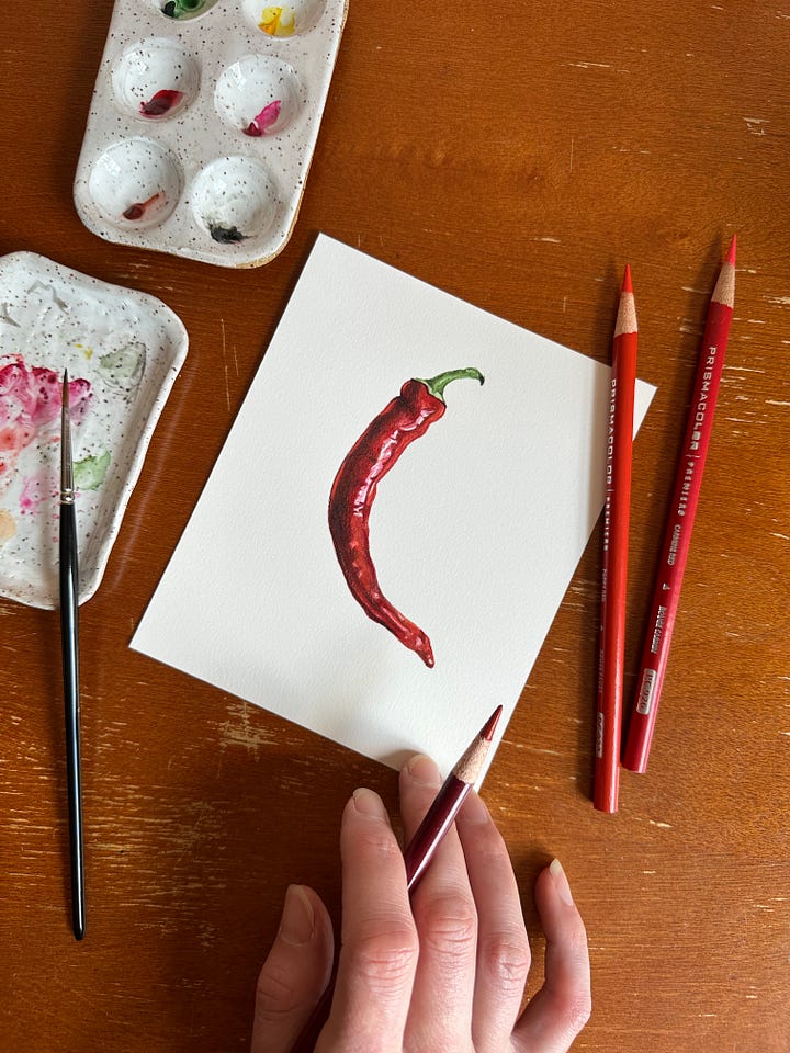 a small painting of a red chili pepper with paintbrush and palette close by, and a painting of a single gardenia flower with real gardenia flowers next to it 