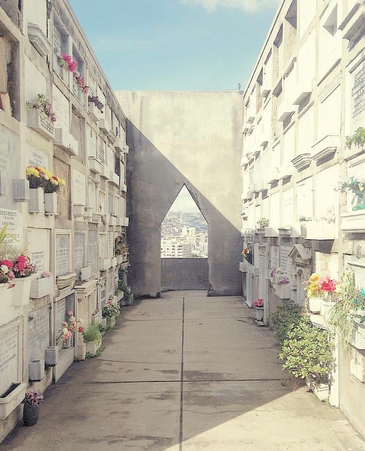 A man walks though the Calle Argentina Flea market on Sunday with a backdrop of a metal spire. The Dissedents Cemetery is perched on a hill overlooking the 