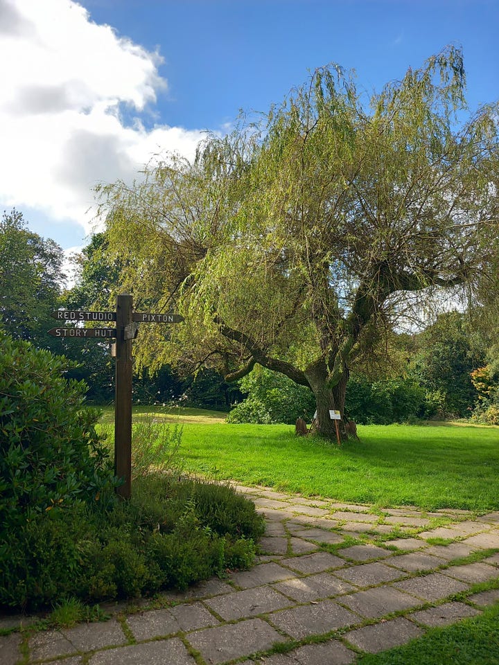 Four pictures: a wooden signpost next to a magnolia tree, a white building set in a tranquil garden and a small library.  