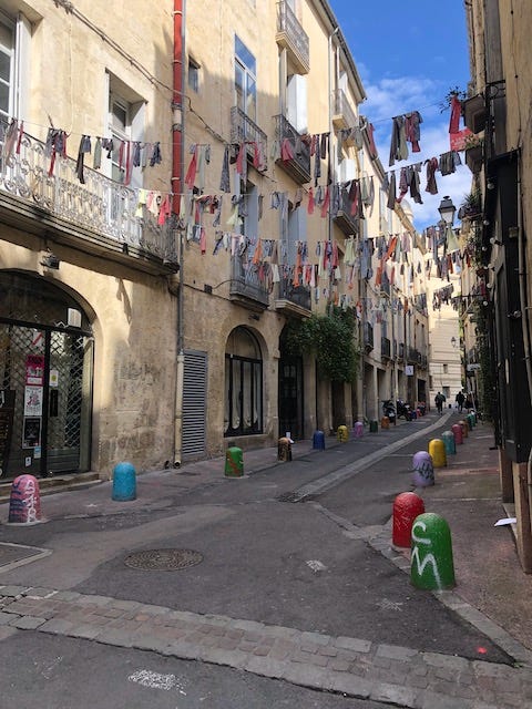 Four photos of medieval streets and buildings in Montpellier, France.