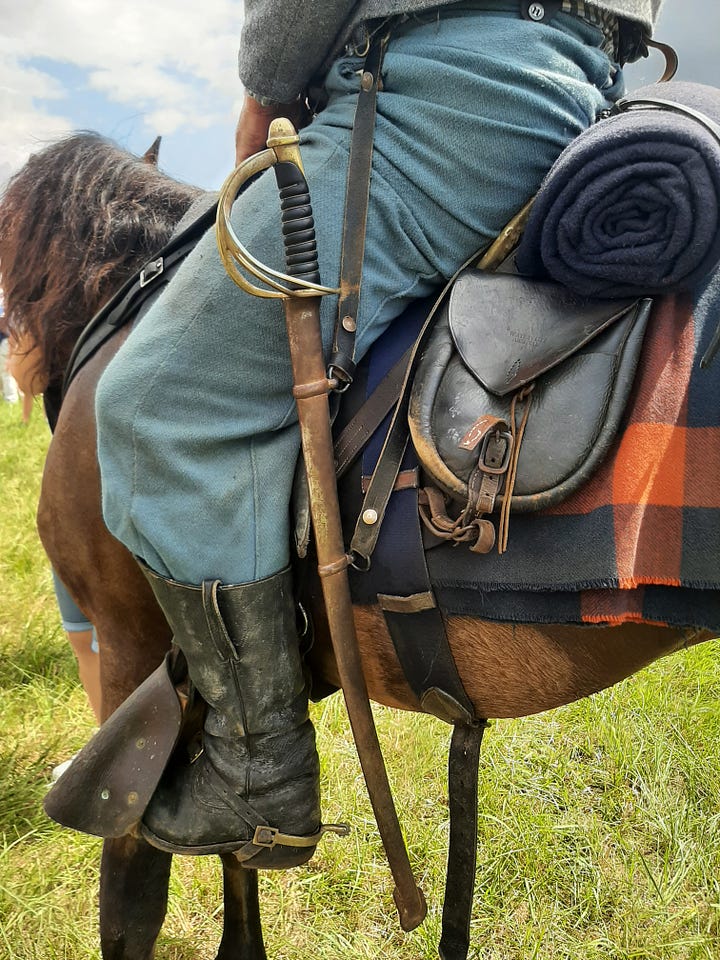 The leg, boot and sword of a cavalry reenactor, along with the different leather equipment they use.