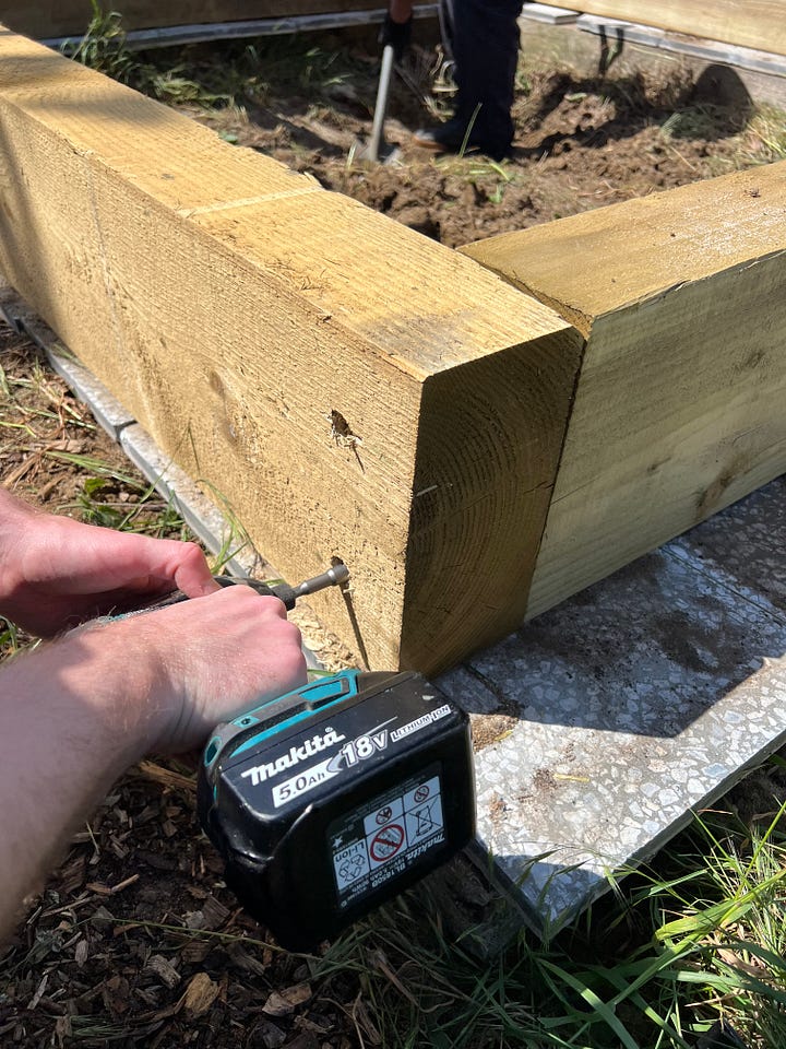 Volunteers using power tools to assemble the pond walls