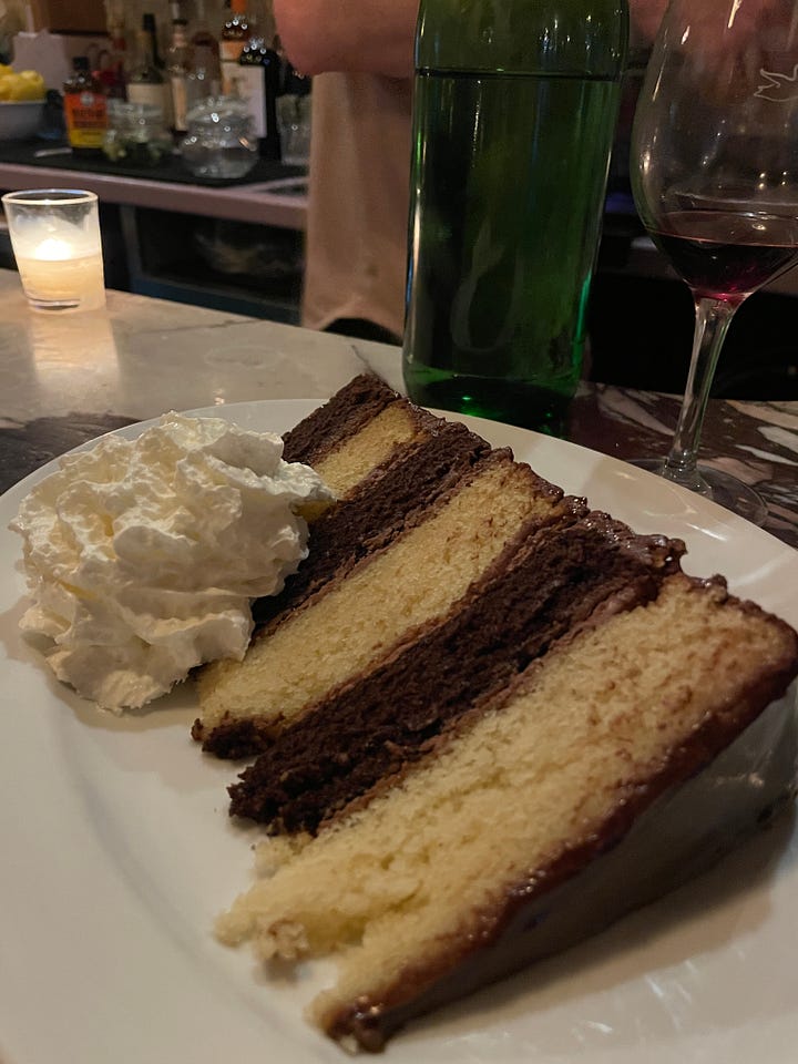 A cheese burger on a challah roll and a seven-layered chocolate cake