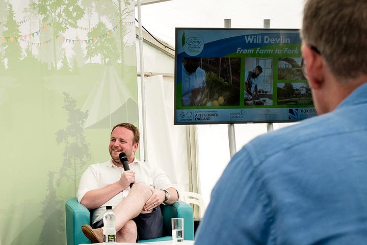 Two people on stage talking, and chef Will Devlin 