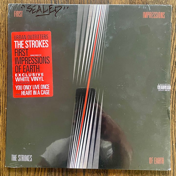 pictures of vinyl records of The Strokes' First Impressions of Earth with Urban Outfitters hype sticker and Azymuth's Spectrum