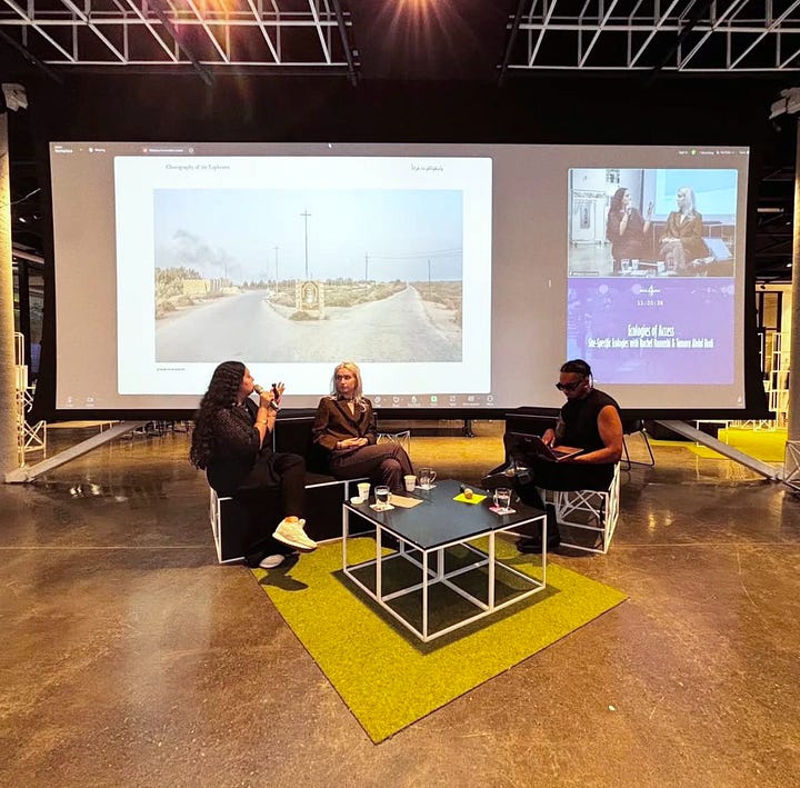 Two square images displayed side by side The first image on the left shows a scene from the Ecologies of Access event at 4th Space, Concordia. AIM member Nick is leading a conversation with participating members and featured artists Rachel and Tamara. Tamara's photography is projected on a screen behind them. The group is seated in the spacious 4th Space gallery. The second image on the right shows AIM's workshop at the 4S East Conference in Amsterdam. From left to right, Jessie, Emery, and Rachel are posing behind their setup. A table displays a poster for 'Reading for Palestine,' AIM Reads book club, hanging in front. A laptop on the table shows a still from the 'AIR, River, Sea, Soil' exhibition. Various AIM stickers are scattered around the table for participants to take home.