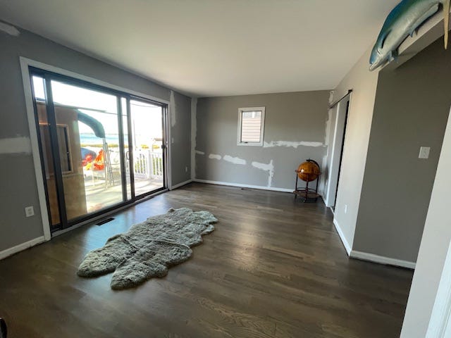 The before bedroom is washed out and doesn't have any focal points. The sliding glass door will end up being the focal point and the dramatic wall color frames the view.