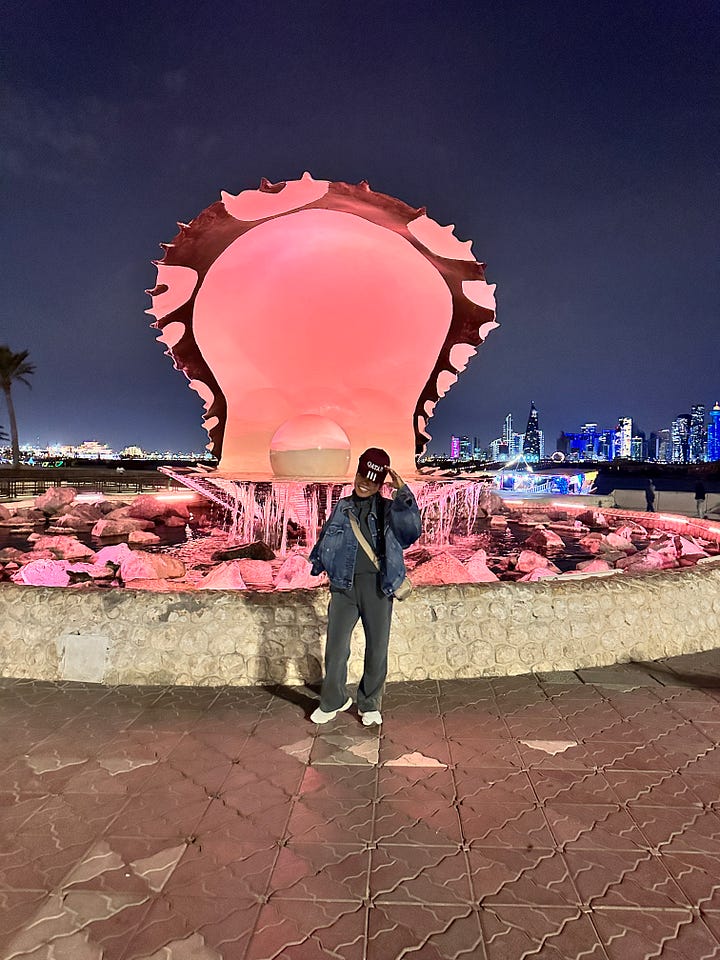 Woman posing in front of The Pearl, Doha Qatar
