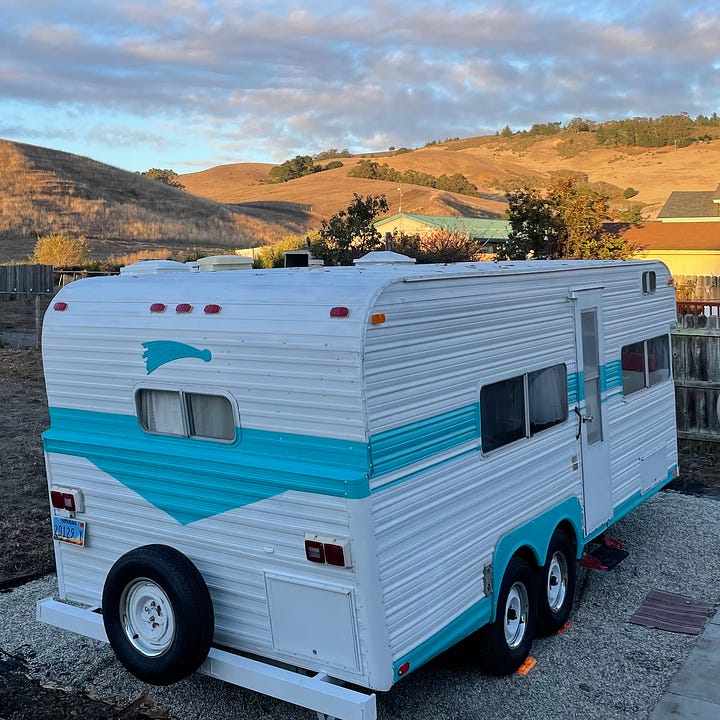 a chicken pen, a little rooster, two shots of a 70s-era travel trailer