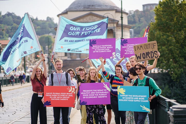 Four colourful images of people queuing to enter the Terra Madre event in Turin in 2022, and one of a large blue snail which is the logo of Slow Food.