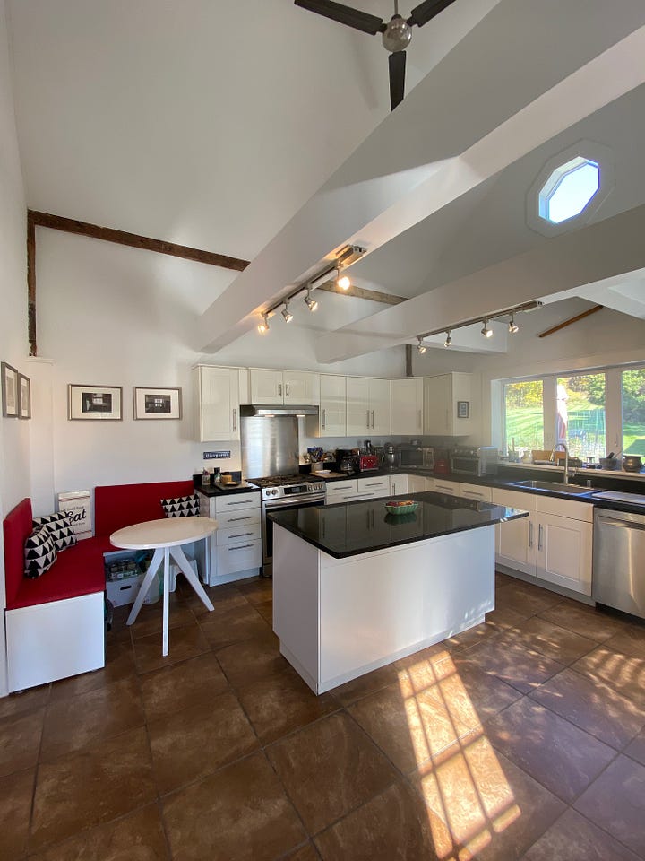 Kitchen with white cupboard doors and walls, and black counter tops.