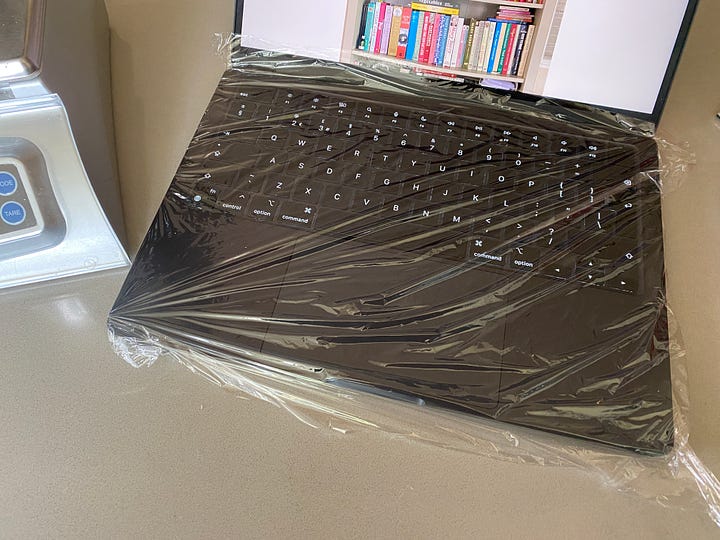 Laptop, airfryer and Thermomix on a counter top.