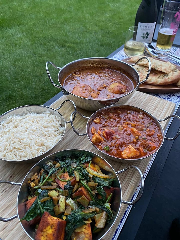 Curry dishes prepared on a tapas board to enjoy alfresco dining alongside a bottle of sparkling wine