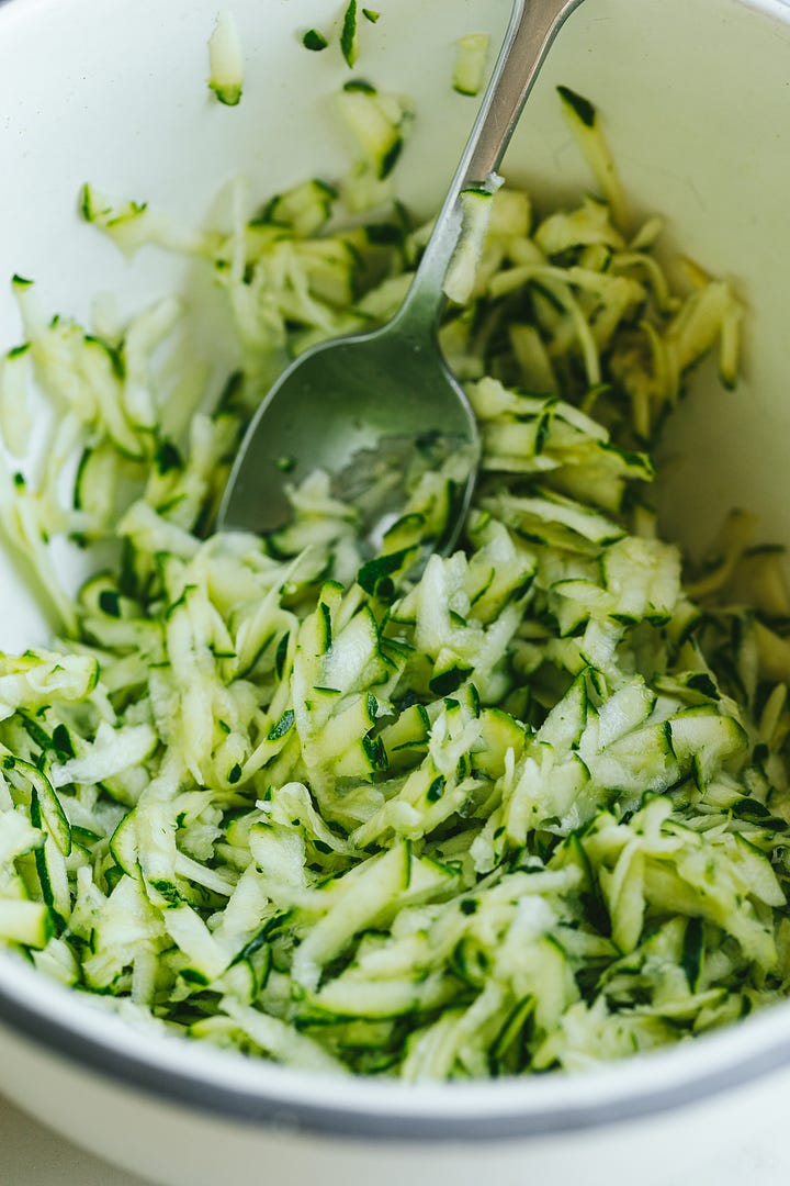 Shredded zucchini and frying the fritters.