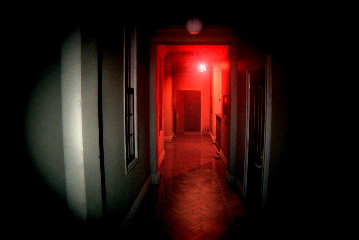 Corner of the L-shaped corridor in P.T.; A wall in the corridor of P.T., there's a marking on the wall saying "HELLO!"; View of the corridor in P.T., this time lit by red lights; Apparition "Lisa" seen from the corner of the corridor, P.T.;