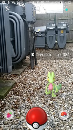 A Pokemon Go screenshot of a Treecko on a kitchen counter and a man in a VR headset with two controllers.