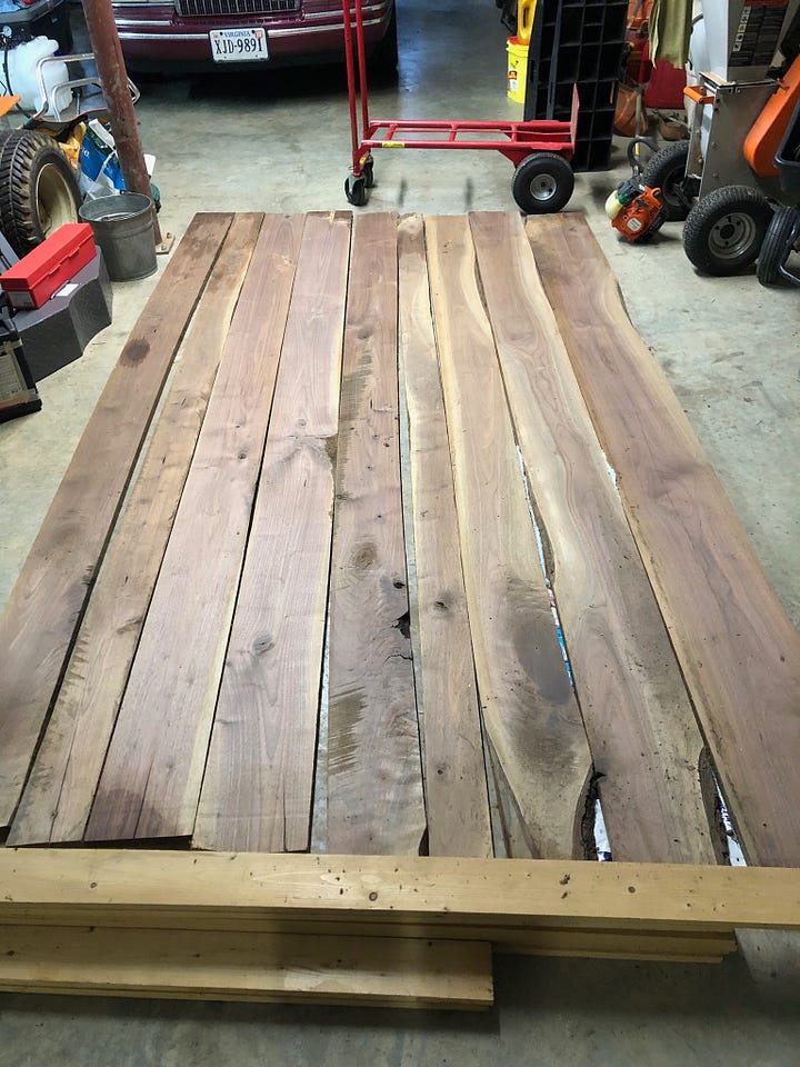 boards lying on garage floor, boards cut and arranged into a tabletop, end piece with dowels, finished and painted