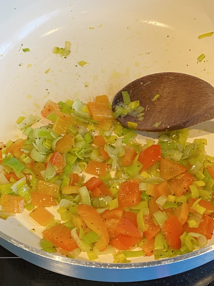 mixed vegetables frying in a large pan.