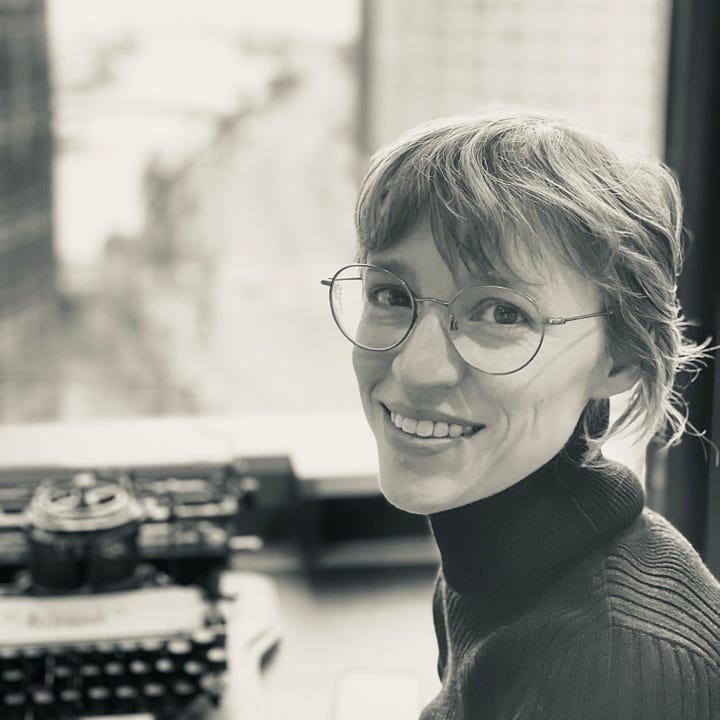 Two photos of Susan, first when she is 26 years old in 2010 with long hair and the glowing skin of youth! Then in 2024, when she is 40 and grinning before typewriter.