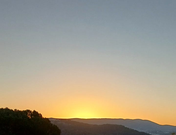 Left: sun rising behind clouds and mountains, with fog in foreground. Right: sun about to rise over mountains in nearly cloudless sky, taken by author from her window.