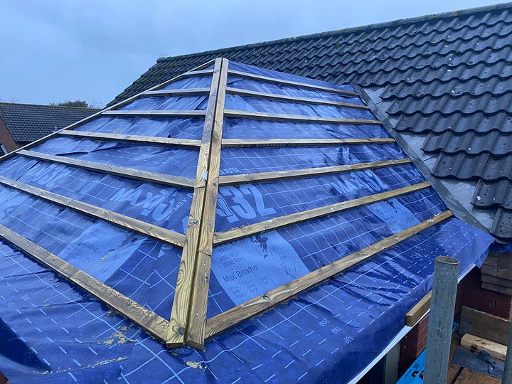 roof covered in blue embrance and wooden batons with lead sheeting down the side