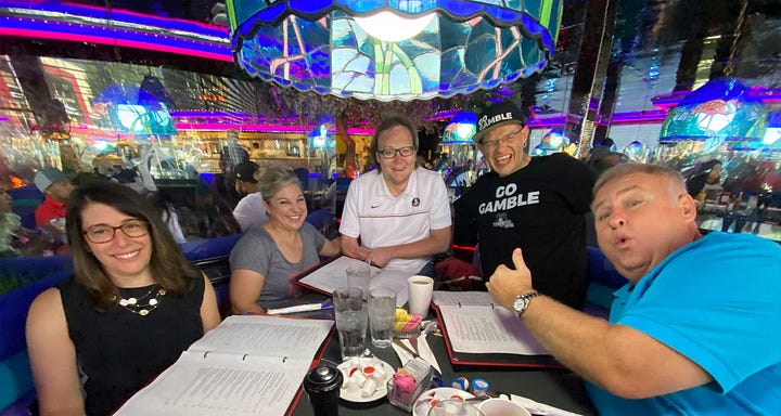 John pictured with friends outside a college football stadium, and also with friends around a restaurant table.