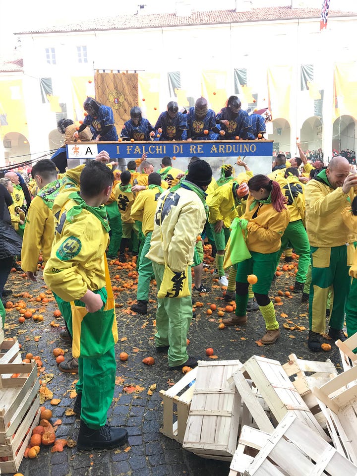 People throwing oranges, others resting after the throwing has finished, a hand holding an orange. All taken in Ivrea.