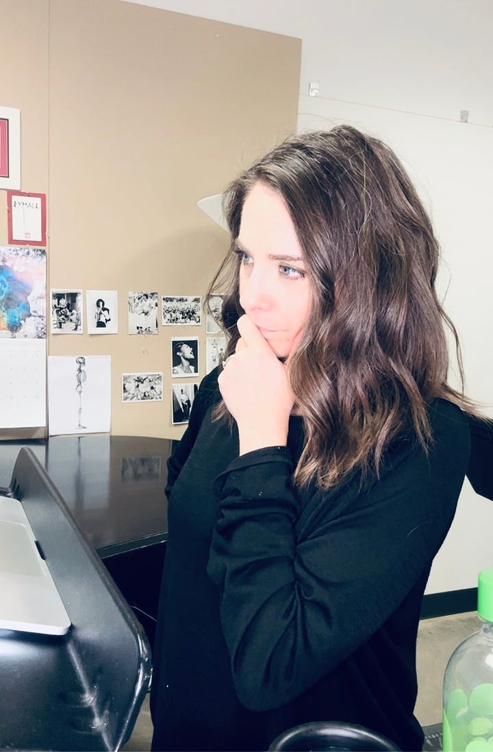 Susan Derry - woman in profile,  medium length brown bob and black sweater, hand on chin. editing the script in a rehearsal room. Howard Breitbart making notes on an iPad while sitting at a piano.