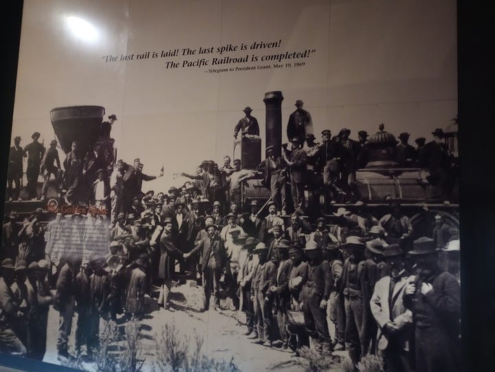 Men alighting from stagecoach, man in pony express office with film showing outside, Crowds gathered around two trains facing each other, and laborers with train