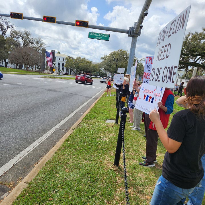 Veterans holding signs in protest of President Trump