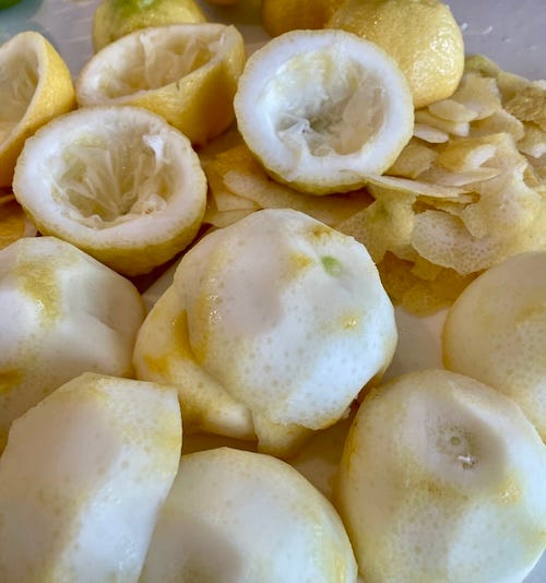 Four photos of step by step of lemon peels being prepared by separating zest from pith, slicing and placing in plastic bags to travel.