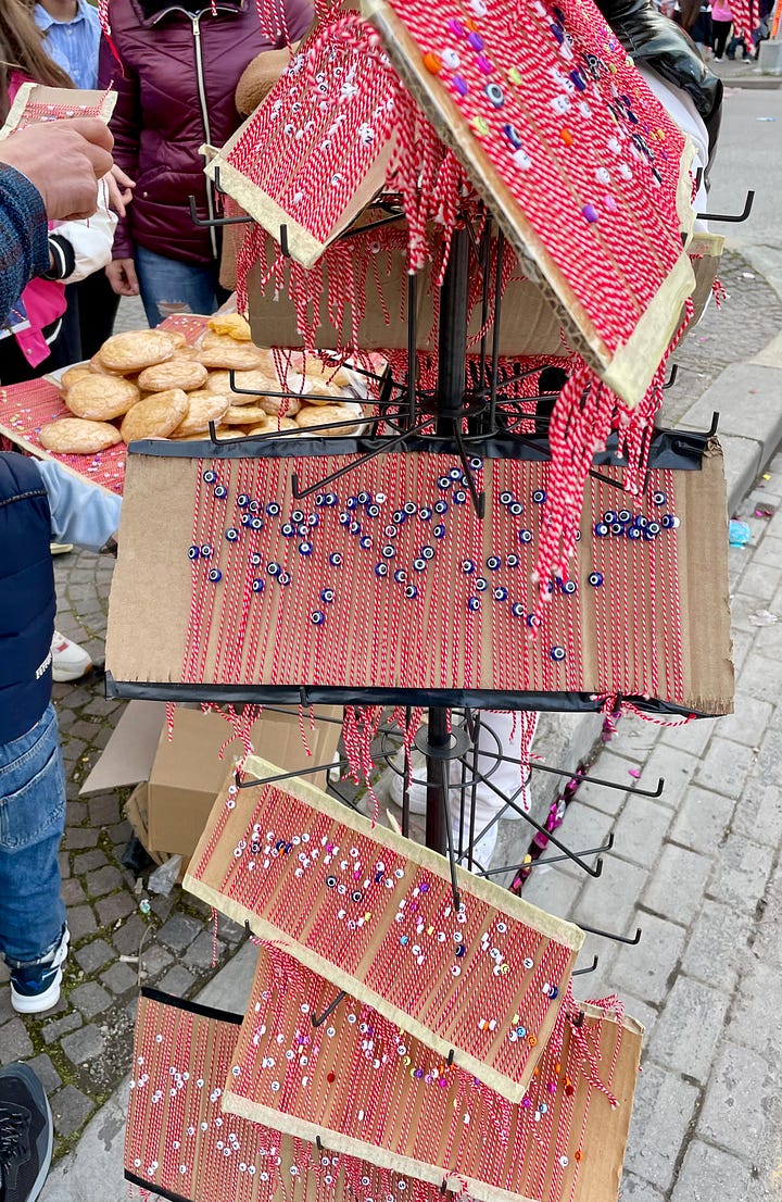 The first image contains traditional Albanian biscuits from Elbasan (bollokume) and "verore" - a summer bracelet given out on the 14th March. The second image contains market stalls and bunting celebrating the day.