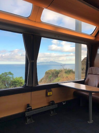 A set of 4 pictures taken from the window of the long-distance train - showing railroad tracks, green bush, and sweeping lake vistas out of a train window