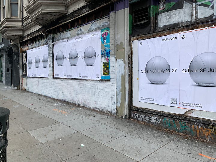 Left: A row of posters with a chrome sphere, reading "Orbs in SF. July 20–27". "Book an appointment to sign up for your World ID". Right: A sticker covering a QR code, which reads in black text: "It's appalling that investors are wasting tens of millions in a new crypto scheme in the name of helping the worlds' poor. If they were really interested in helping low-income communities, they should give away their money instead of investing in yet another form of surveillance." - The Surveillance Technology Oversight Project