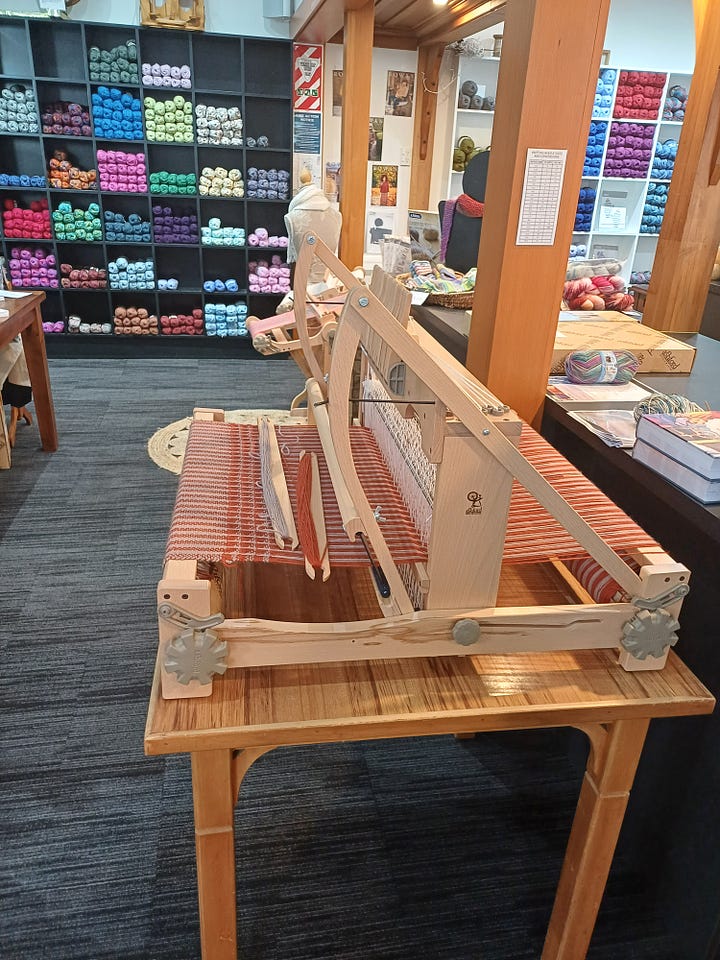 1: A horizontal loom in the foreground; skeins of coloured yarn in the background. 2: Several kinds of spinning wheel and some machines I think meant to turn skeins into balls of yarn?