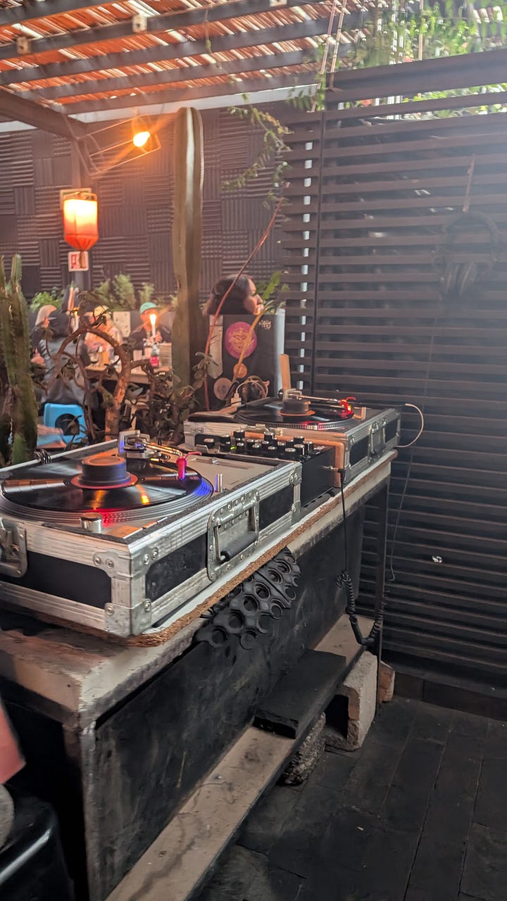A rooftop turntable set. Dragon trees and art on a staircase.