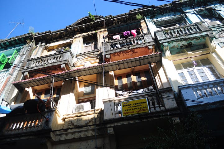 Images of cars on a main road and an old building in Yangon