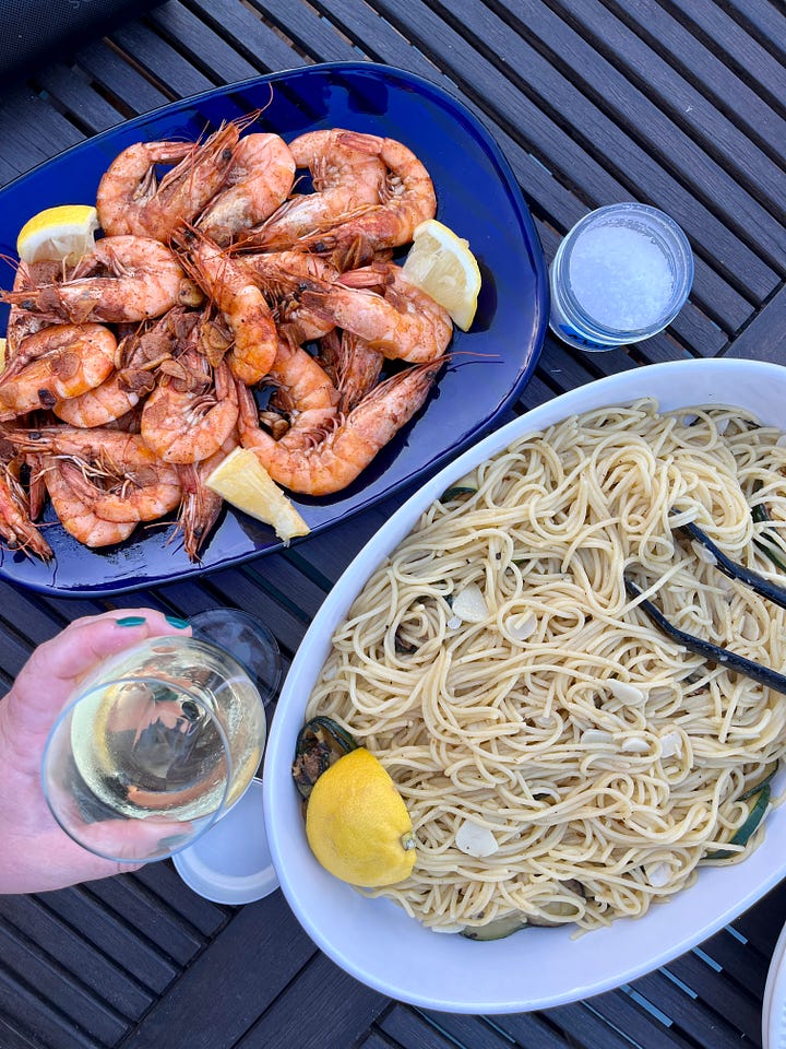 a dinner of shrimp and pasta, a plate of jamón